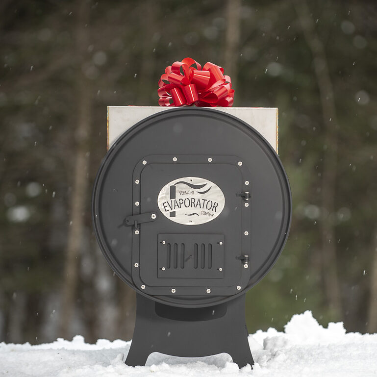 a red bow on a backyard maple syrup evaporator