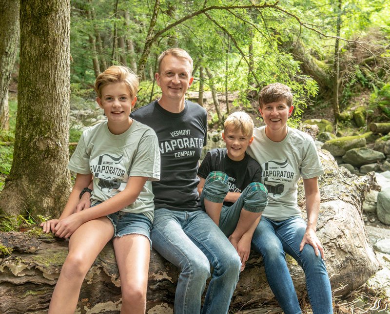 smiling family in woods wearing vermont evaporator company tees