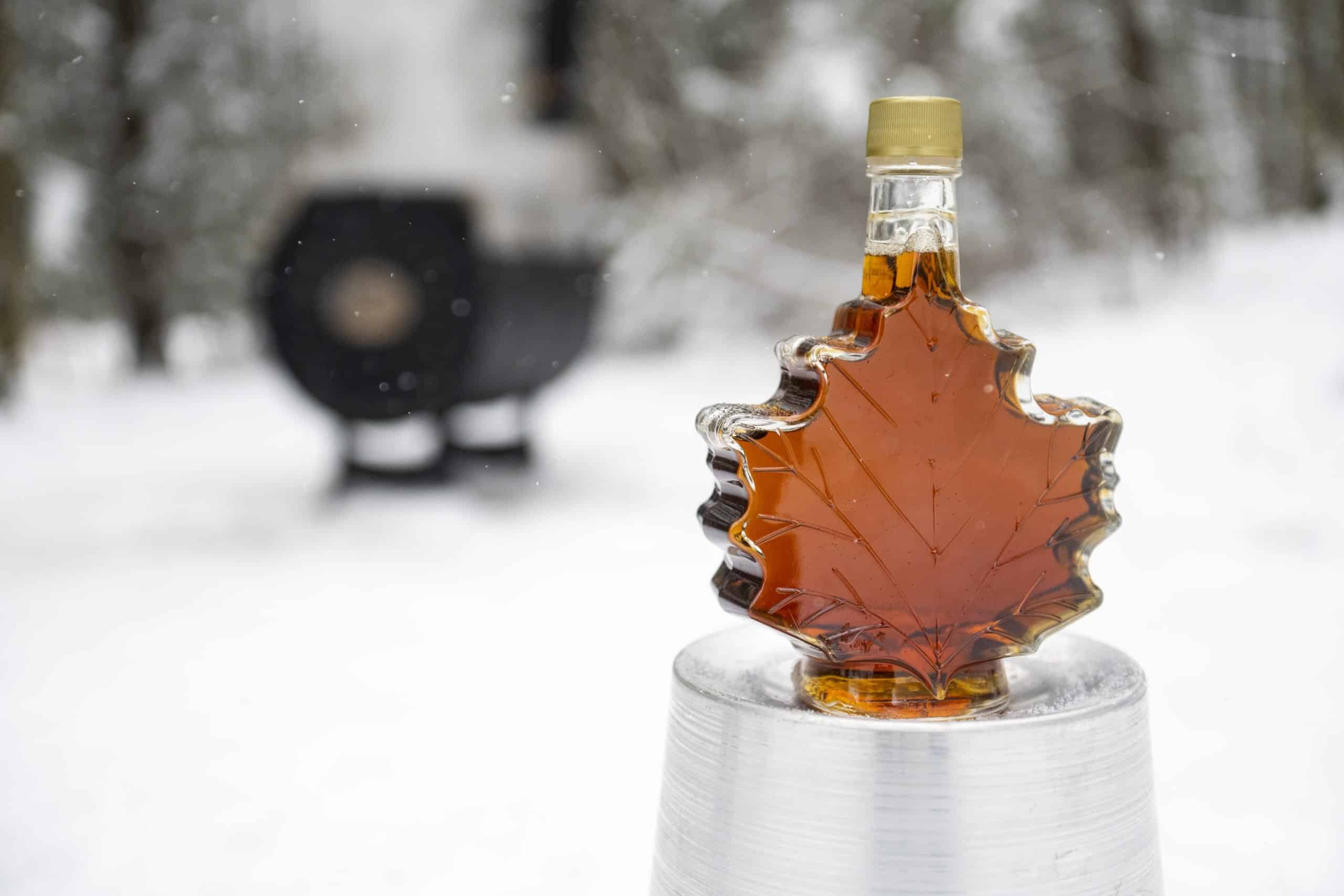Maple leaf maple syrup bottle with maple syrup evaporator in the background