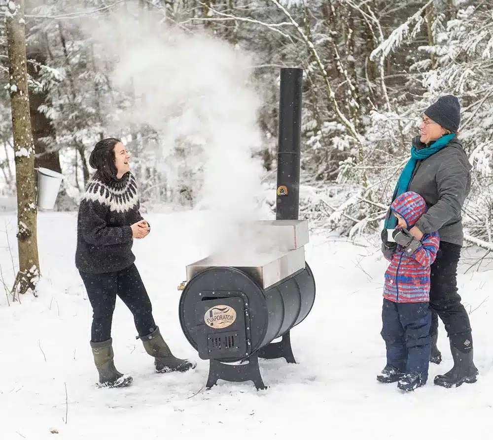 People making maple syrup on an evaporator