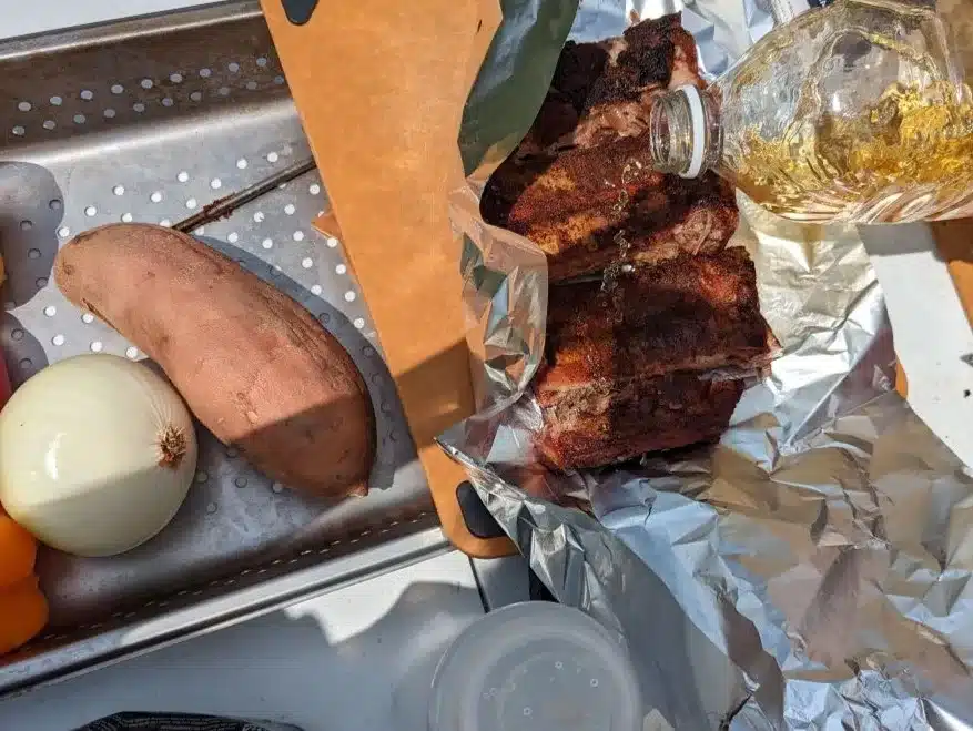 Wrapping ribs in aluminum foil with juice.